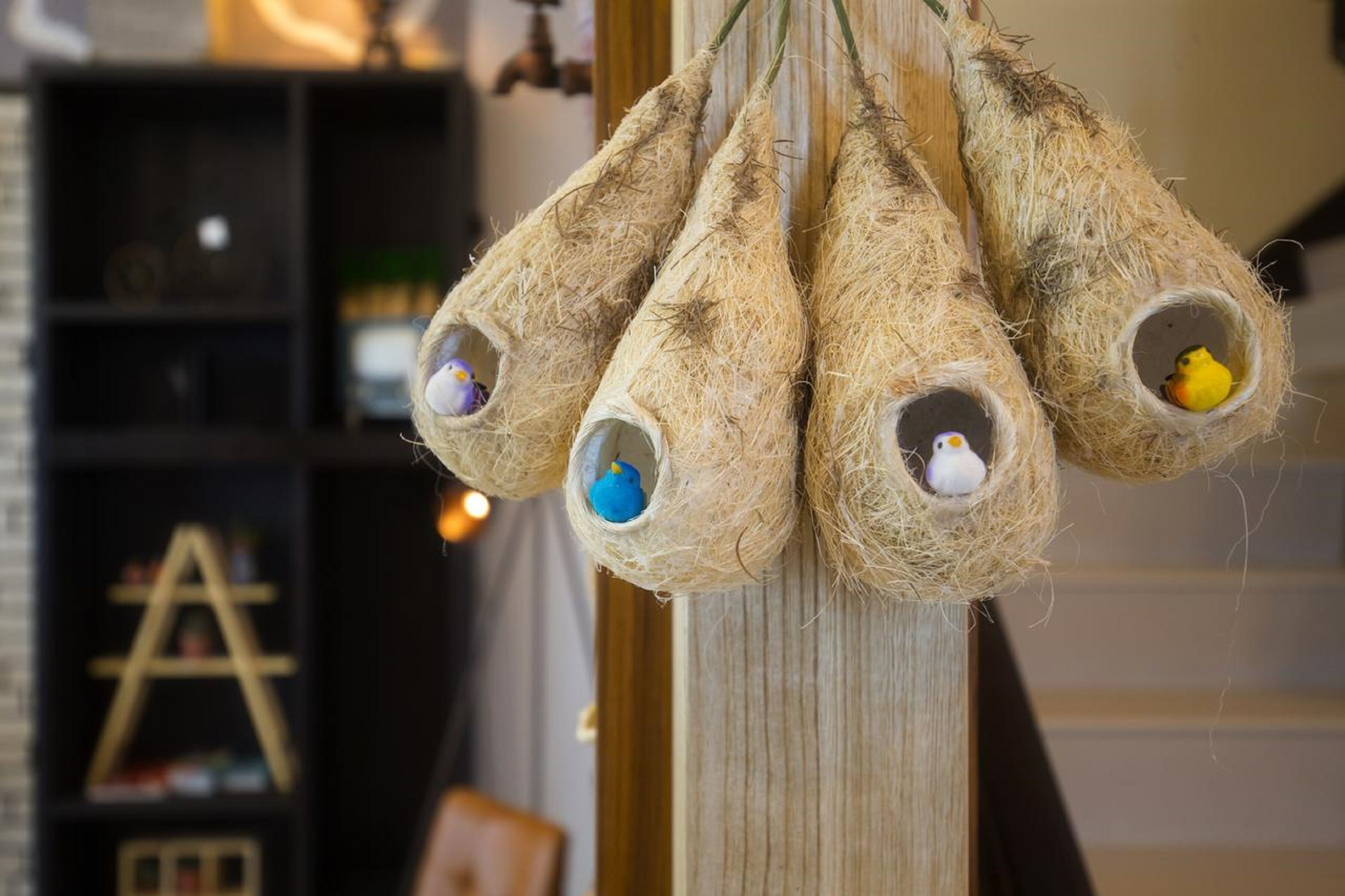 A wall with a decorative hanging made of natural materials, possibly for birds.