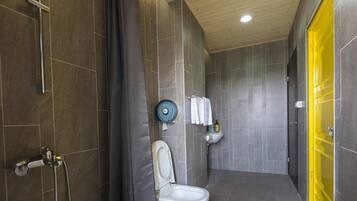 A modern bathroom with a shower, toilet, and sink.