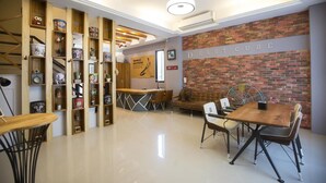 Ein modernes Interieur mit Backsteinwand, Holzböden und einer Sitzecke mit Tisch und Stühlen.