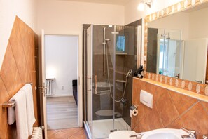 A modern bathroom with a glass-enclosed shower, a white sink, and a large mirror. - Ferienhaus Domblick Herkenrath (Bergisch Gladbach)