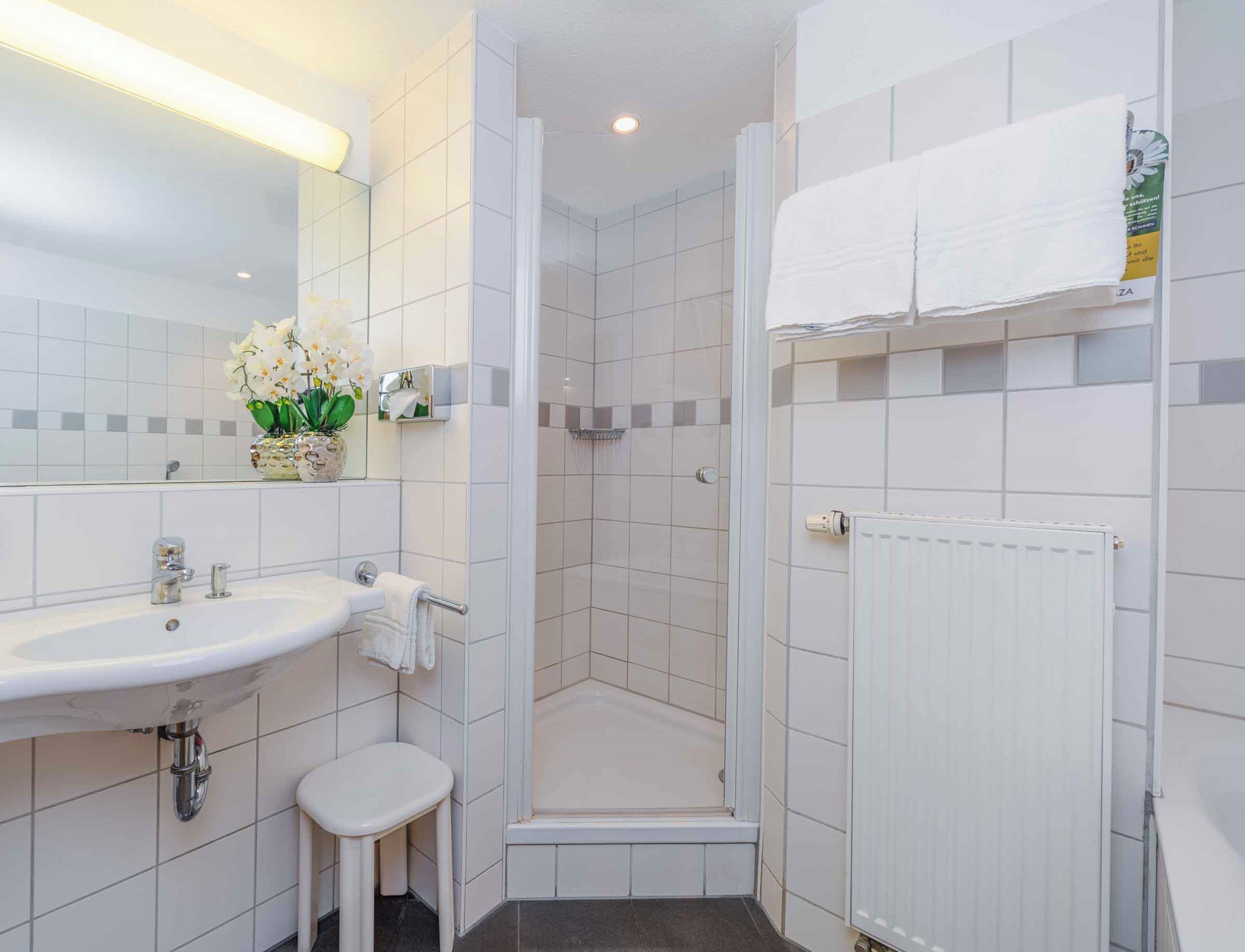 Ein modernes Badezimmer mit Waschbecken, Toilette und Duschbereich.