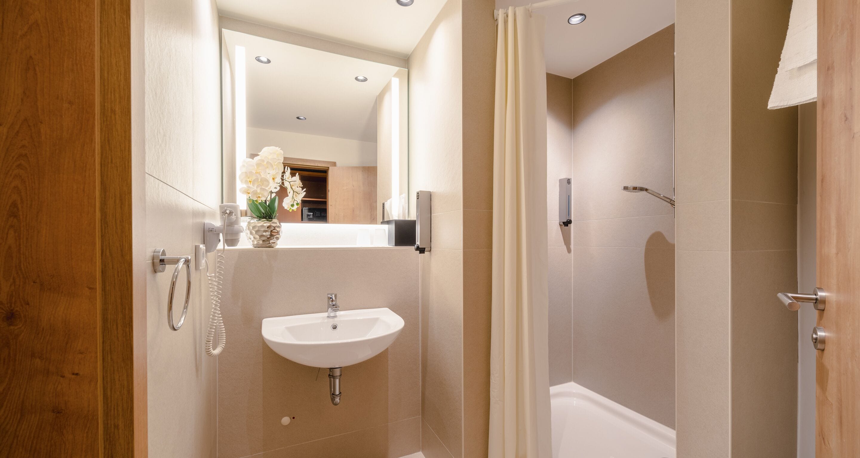 Ein modernes Badezimmer mit Waschbecken, Spiegel und Dusche.