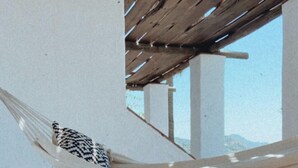 A hammock in a room with a tiled floor and a woven mat. - La Posada Morisca (Frigiliana)