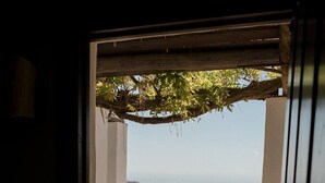 A balcony with a hammock, a chair, and a view of a hilly landscape. - La Posada Morisca (Frigiliana)