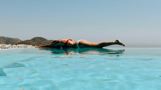 A person lying on a boat in a clear blue sea. - La Posada Morisca (Frigiliana)