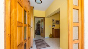 A hallway with wooden doors, a rug, and a tiled floor. - Beautiful home in Labin (Labin)