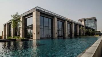 A modern building with large windows and a swimming pool in front.