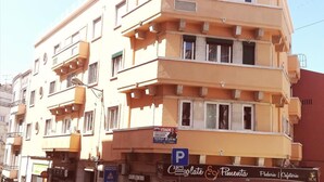 A multi-story building with balconies, a visible ground floor cafe, and a sign for "Lisbon Terrace Suites" on the top floor. - Guesthouse Sweet Liberdade (Lisbon)