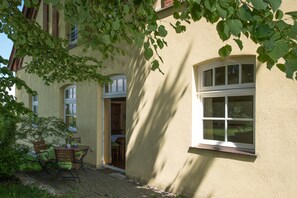 A building with a paved entrance, a door, and a window. - Ostsee-Landhaus (Bastorf)