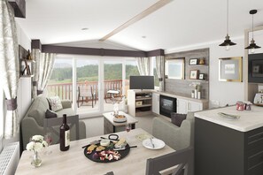 A spacious living area with a balcony, a dining table set with food and drinks, and a television mounted on the wall. - Cardigan Bay Holiday Park (Cardigan)