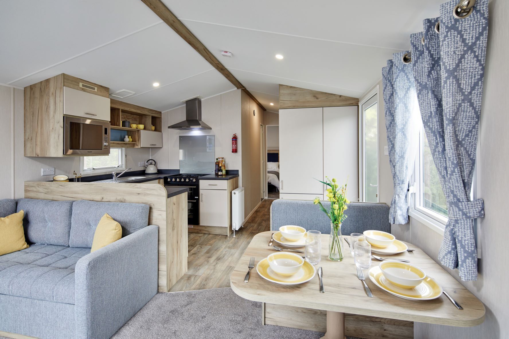 Een compacte keuken met moderne apparatuur, een eetgedeelte met een tafel voor vier personen, en een gezellige zithoek.