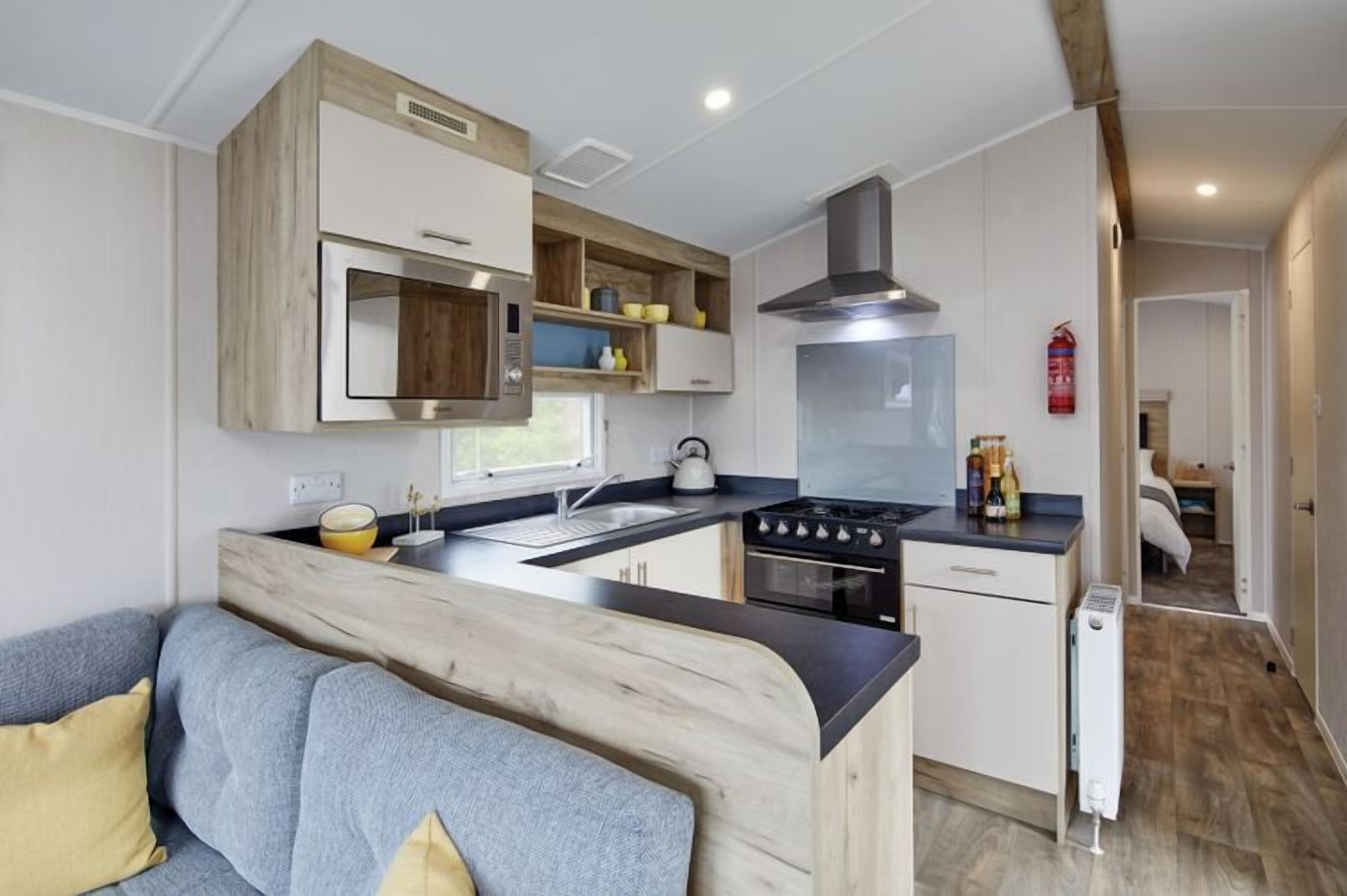 A compact kitchen with a central island, built-in cabinets, and a stove.