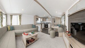 A spacious RV interior with a living area, kitchen, and entertainment space. - Cardigan Bay Holiday Park (Cardigan)