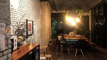 A cozy dining area with a brick wall, wooden table, and chairs.
