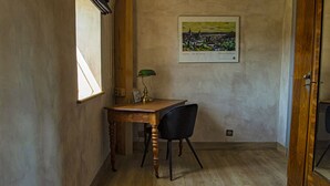 A room with a wooden desk, a chair, a window, and a framed picture on the wall. - Le Terminus (Tournus)