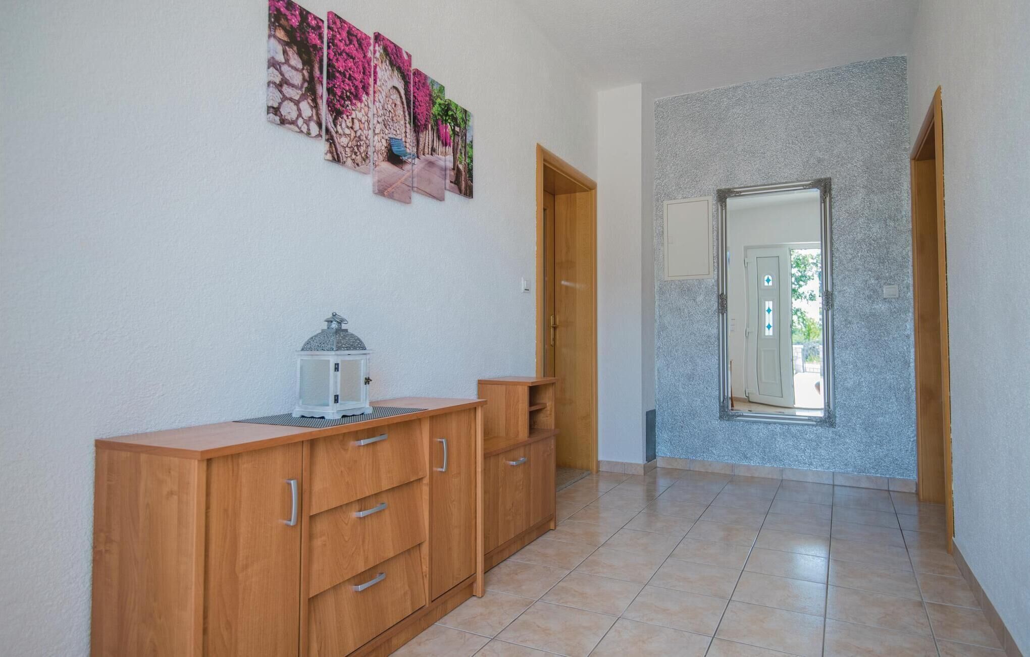 Ein Flur mit einem Holzschrank, einer weißen Laterne und einem an der Wand befestigten Kunstwerk.