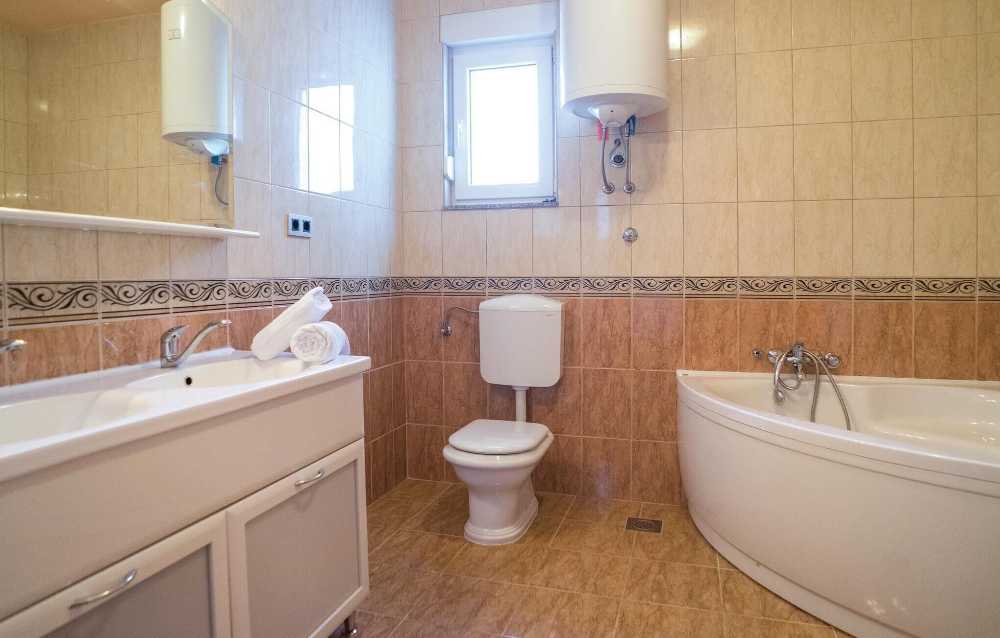 A bathroom with a sink, toilet, and bathtub.
