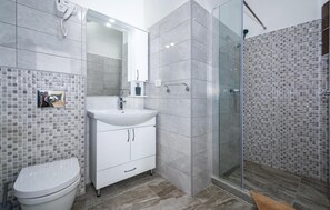 A modern bathroom with a toilet, sink, and shower. - Luxurious home in Plomin (Plomin)