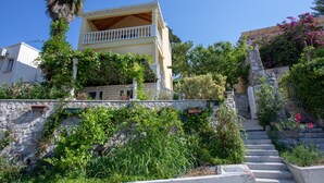 A building with a balcony, surrounded by greenery and a stone staircase. - Villa Zlata (Zupa dubrovacka)