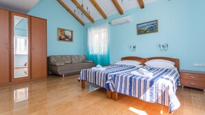 A bedroom with a bed, a sofa, a wardrobe, and a window with curtains. - Villa Zlata (Zupa dubrovacka)