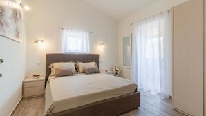 Une chambre à coucher avec un grand lit, des tables de chevet, une commode, un miroir et une armoire.