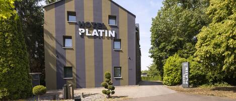 A modern building with the sign "HOTEL PLATIN" indicating a hotel.