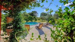 A pool area with two lounge chairs, surrounded by greenery and a clear blue sky. - Lovely home in Pula with WiFi (Pula)