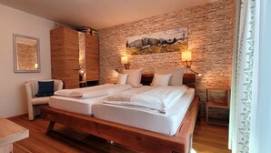 Um quarto com uma cama de madeira, uma parede de pedra e uma pintura.