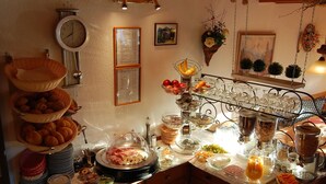 Buffet com diversos tipos de comida e um relógio na parede.