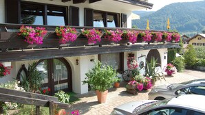 Edifício com varanda decorada com jardineiras e plantas em vasos.