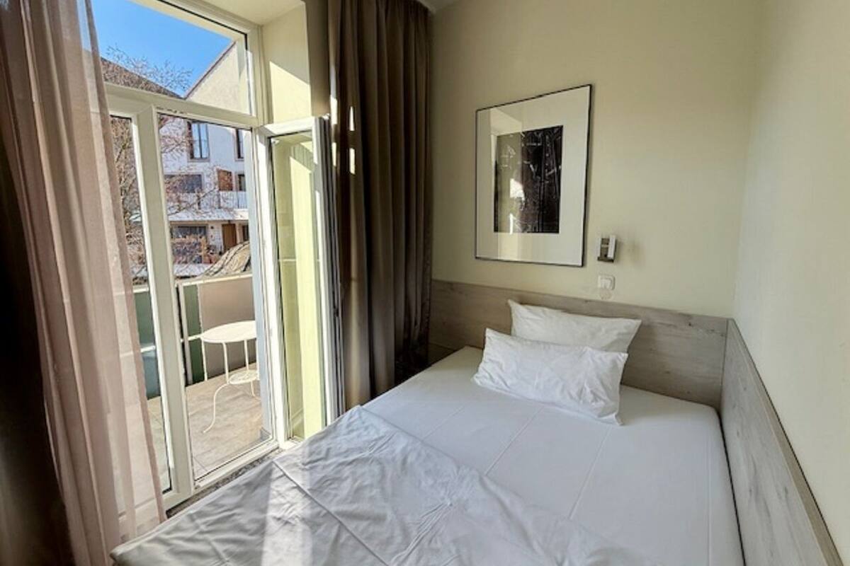 Una habitación de hotel con una cama, una ventana y vistas al exterior.
