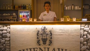 A bar area with a sign reading "WIENIAWA" and a bartender behind the counter.
