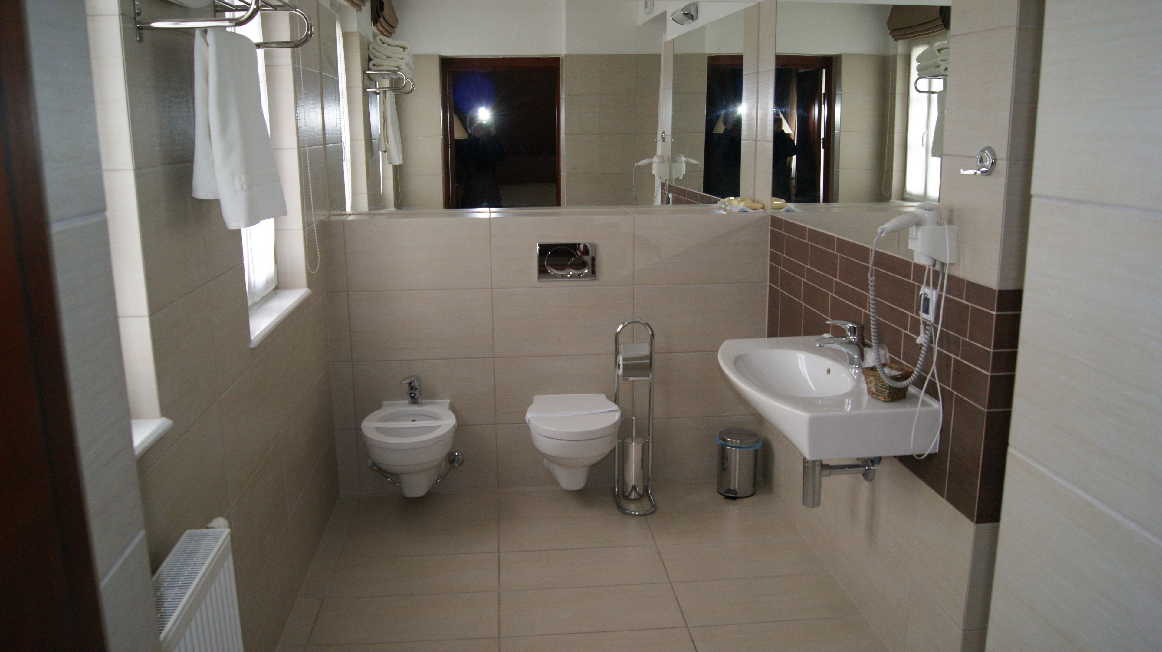 A bathroom with a toilet, bidet, and sink.