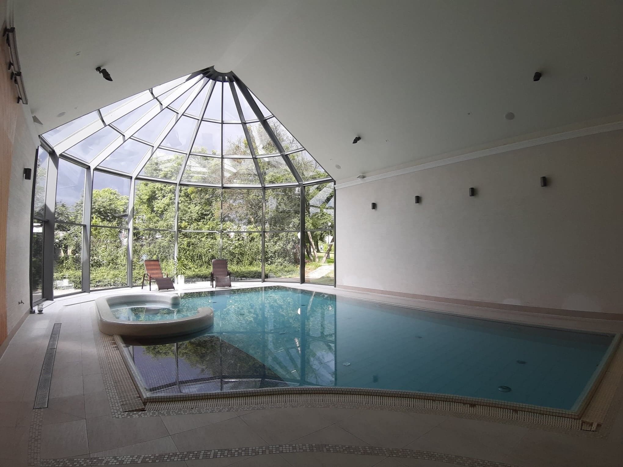 Una piscina techada, sillones reclinables de piscina