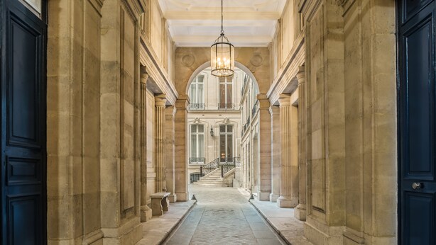A corridor with stone walls and a tiled floor leading to a staircase. - Hotel Alfred Sommier (Paris)