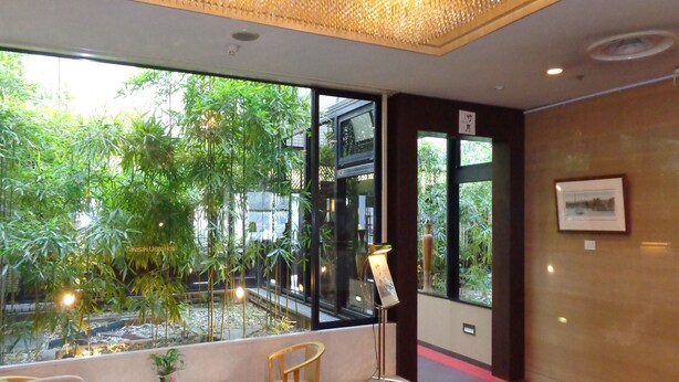 A room with a large window, a table, chairs, a small plant, and a framed picture on the wall. - Takasaki Urban Hotel (Takasaki)