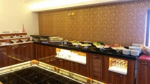 A buffet area with various food options, a coffee station, and a decorative wall. - Gevher Hotel (Kayseri)