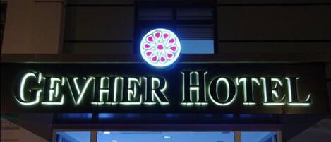 The exterior of the Gevher Hotel with a prominent illuminated sign.