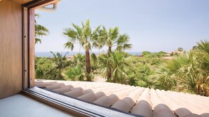 A view from a window overlooking a coastal landscape with palm trees and a clear sky. - Lovely home in S. Maria di Ricadi VV with WiFi (S. Maria di Ricadi VV)