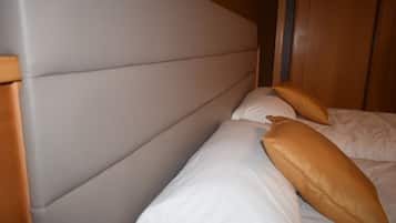 Una cama con cabecera y dos almohadas.