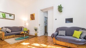 A living room with two sofas, a coffee table, and a vase with flowers.
