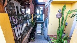A narrow stairway with a wrought iron railing, potted plants, and a small balcony with a view. - B&B Villa Felice (Giardini Naxos)