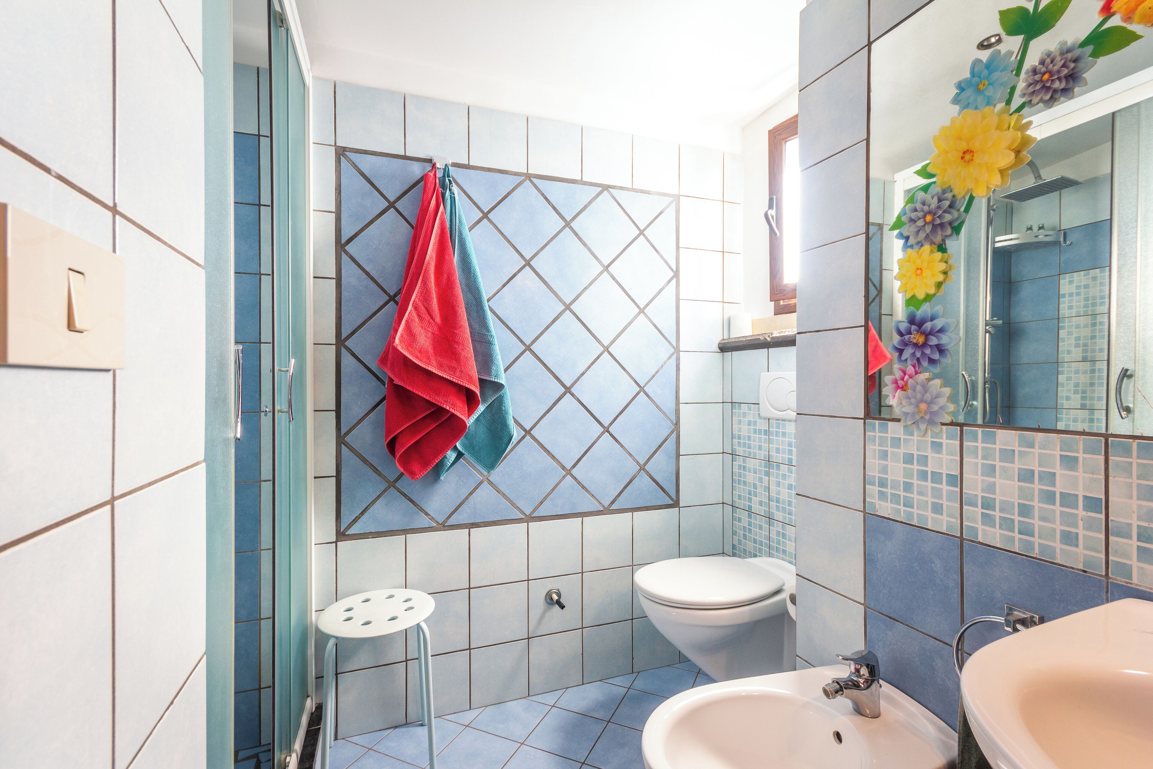 Ein Badezimmer mit Dusche, Toilette und zwei Waschbecken.