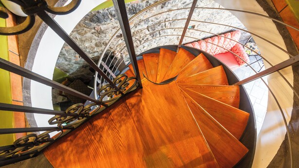 A spiral staircase with wooden steps and metal railings. - B&B Villa Felice (Giardini Naxos)
