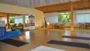 A yoga and meditation center with wooden floors, yoga mats, and wicker furniture. - Villaggio Borgo degli Ulivi (Sellia Marina)