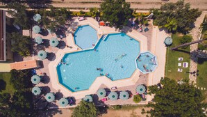 An aerial view of a resort with multiple swimming pools, sun loungers, and umbrellas. - Villaggio Borgo degli Ulivi (Sellia Marina)