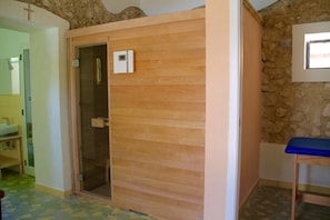 A room with a wooden panel wall, a small window, and a blue bench. - Villaggio Borgo degli Ulivi (Sellia Marina)