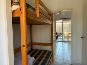 Relax in a cozy space with a lower bunk bed and sliding door leading to an outdoor area.