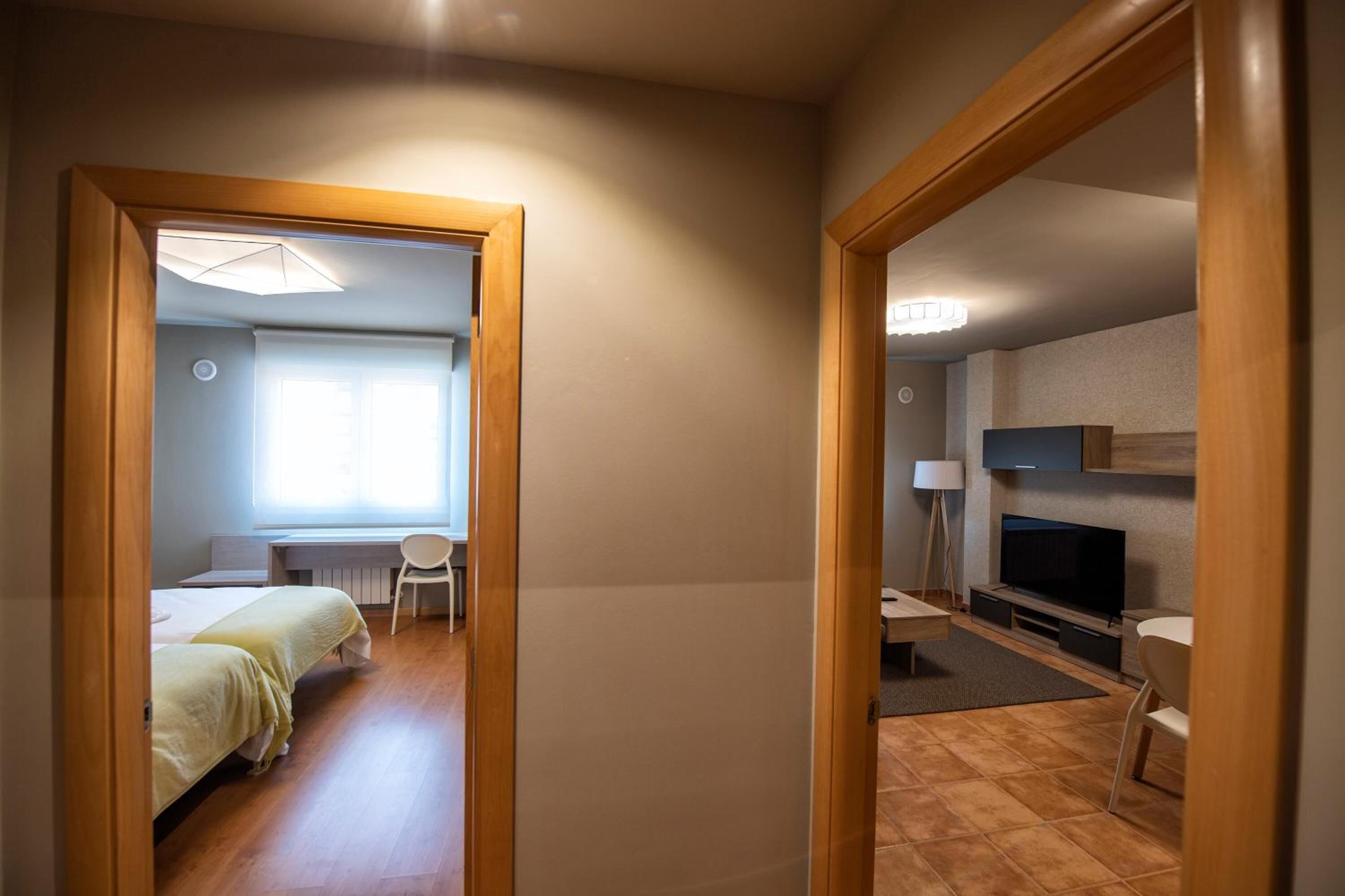 Une chambre d’hôtel équipée d’un lit, d’un bureau, d’une chaise, d’une télévision et d’un miroir.