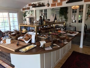 Montaje de bufé con diversos alimentos y una estación de café.